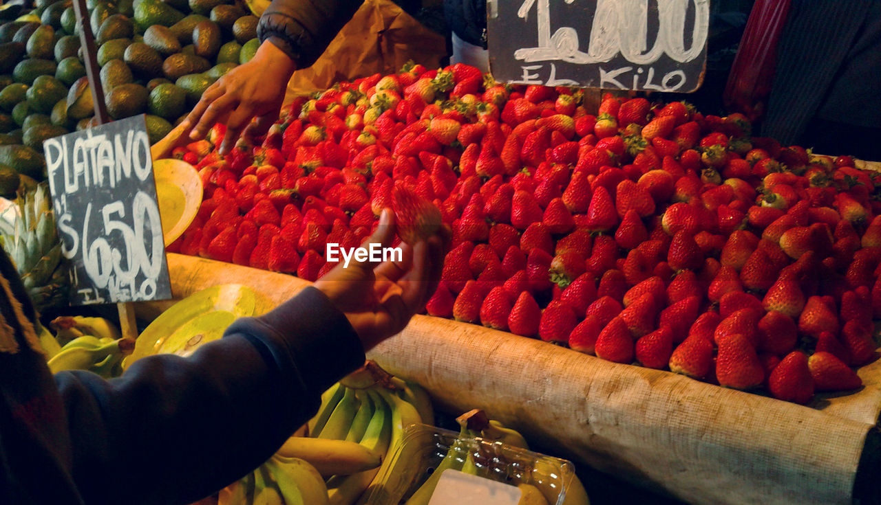 Cropped image of hand holding strawberry in market