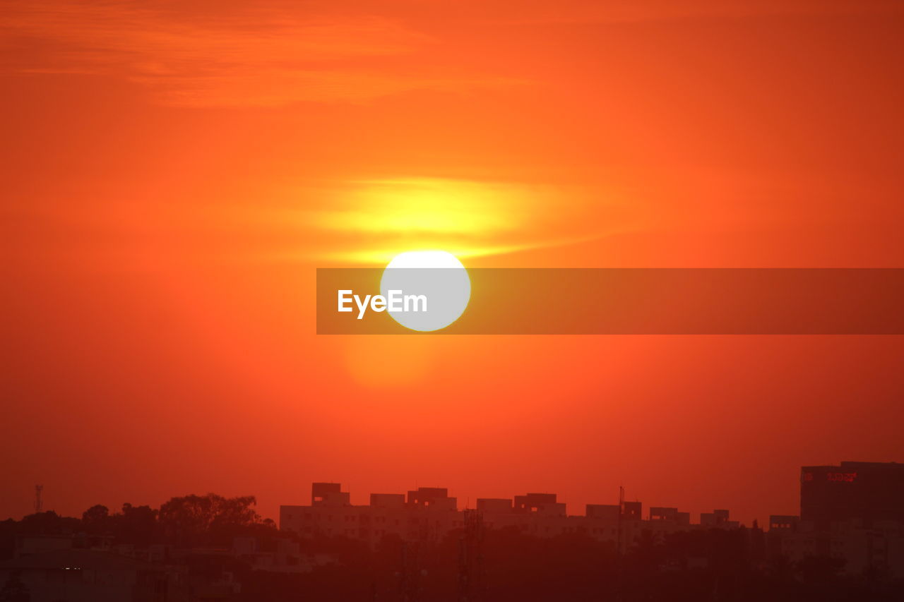 sky, sunset, afterglow, horizon, city, architecture, building exterior, sun, orange color, built structure, nature, cityscape, urban skyline, sunlight, dawn, beauty in nature, landscape, building, no people, dramatic sky, astronomical object, scenics - nature, red sky at morning, outdoors, silhouette, tranquility, cloud, environment, evening, orange, residential district, idyllic, travel destinations, romantic sky, tranquil scene, city life, red, yellow, skyscraper, office building exterior, copy space, atmospheric mood