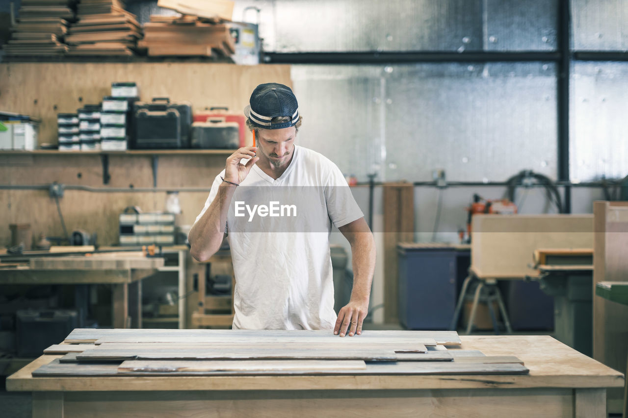 Carpenter working at workbench in workshop