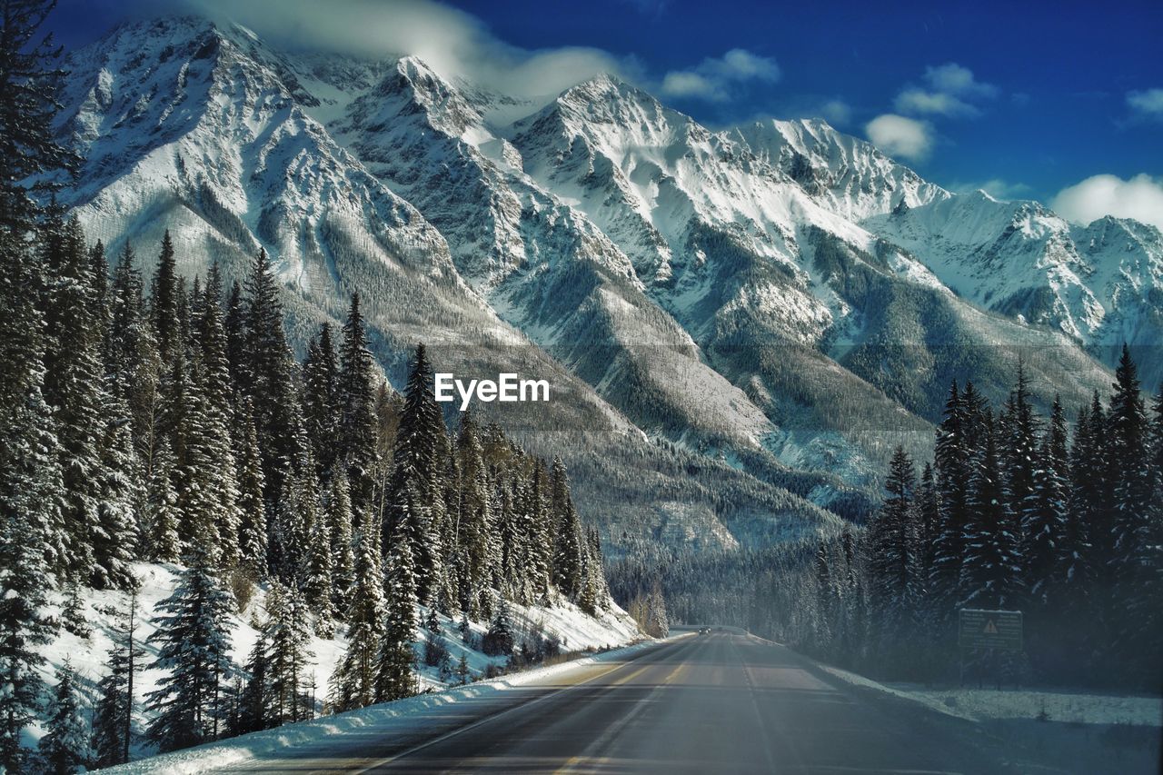 Road amidst snowcapped mountains against sky