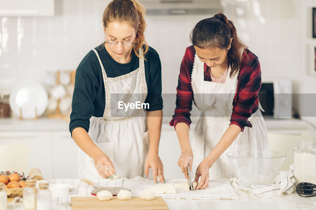 Woman make bread on board in kitchen