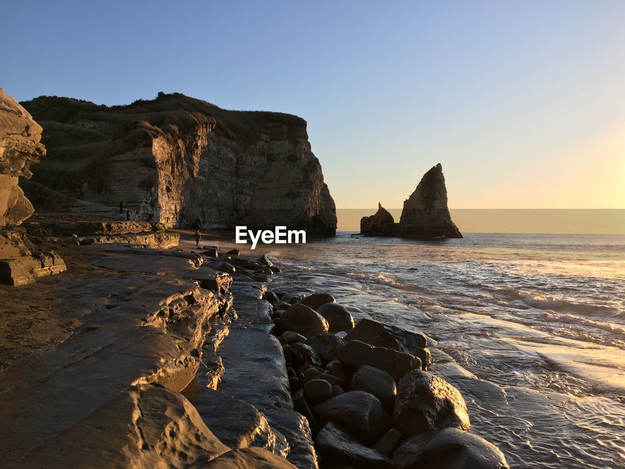 Rock formation in sea against clear sky