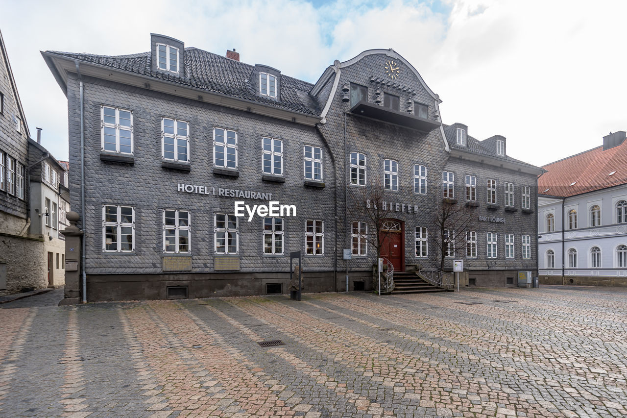 EXTERIOR OF OLD BUILDING BY STREET AGAINST SKY