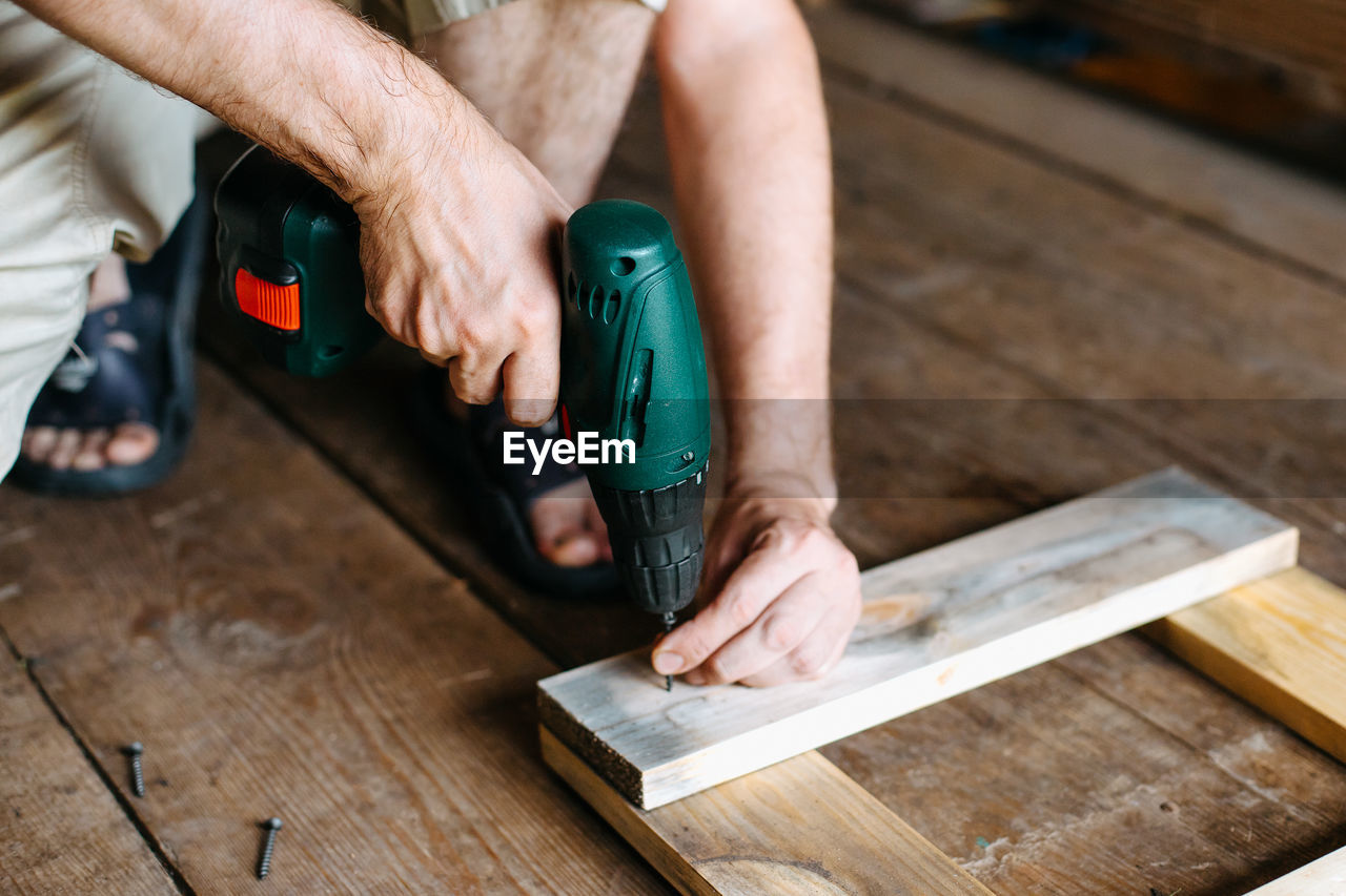 Work with a screwdriver. sewing together wooden block with a screw