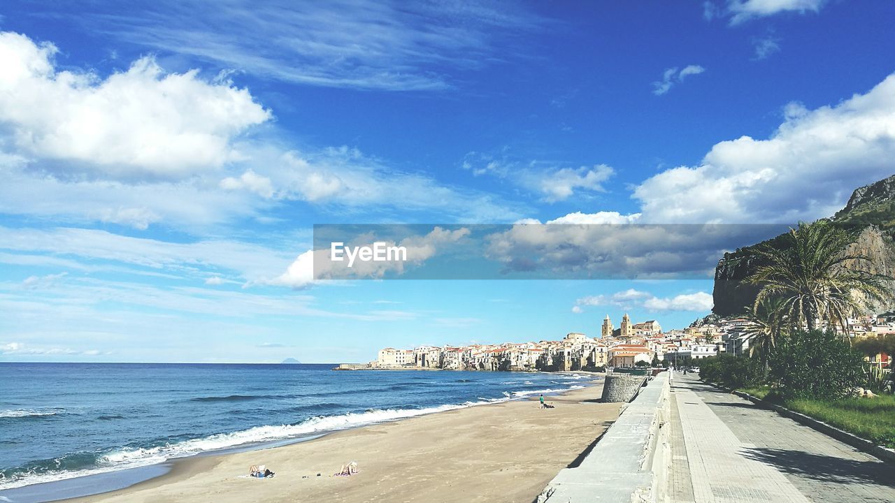 Scenic view of beach against cloudy sky