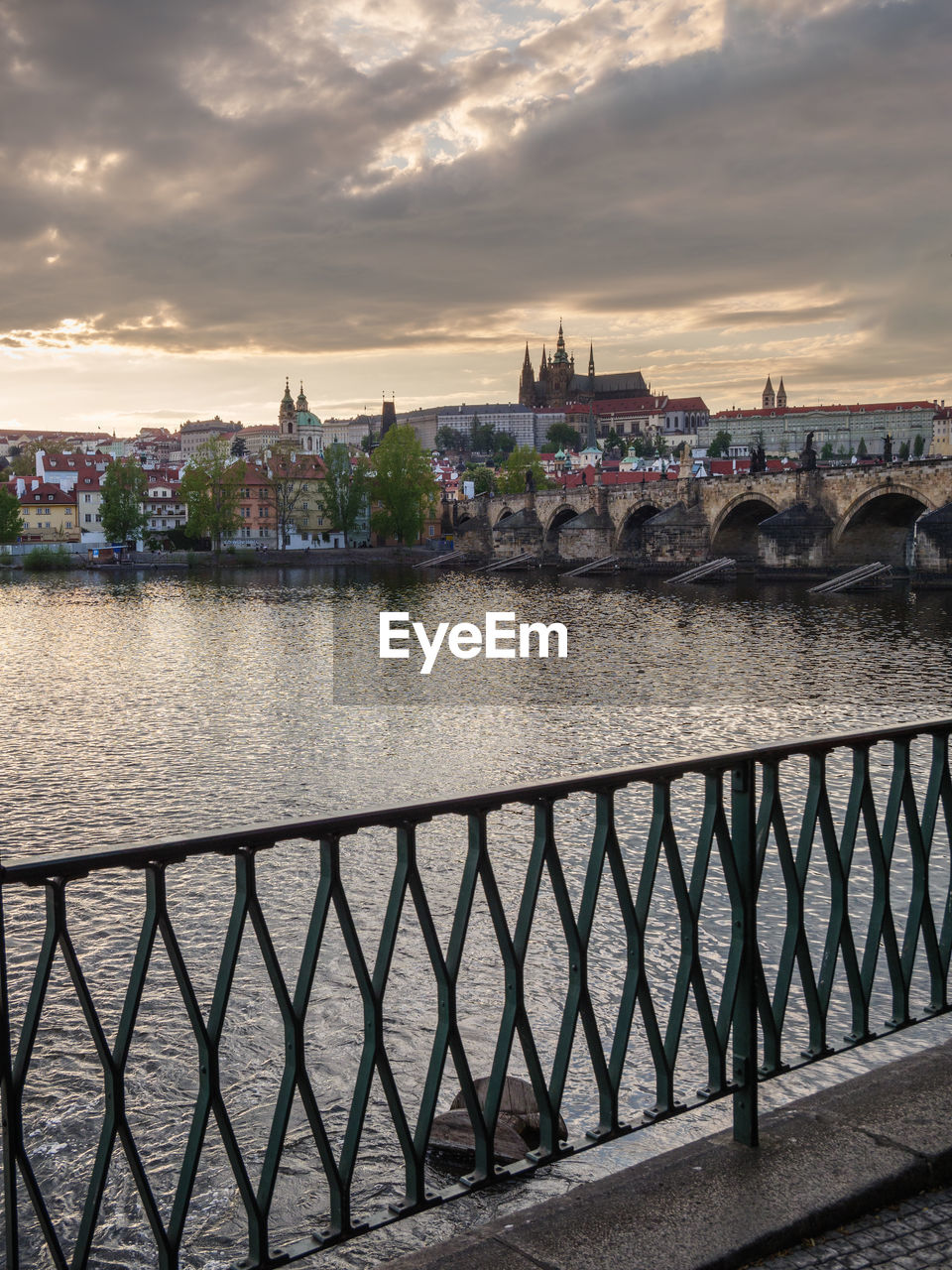 BRIDGE OVER RIVER IN CITY AGAINST SKY