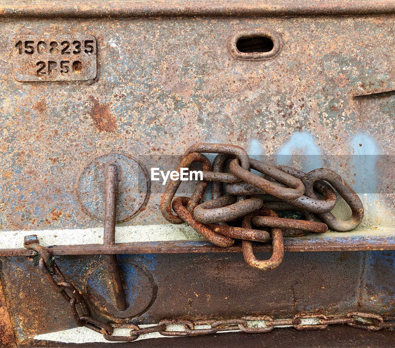 CLOSE-UP OF RUSTY METAL CHAIN ON OLD MACHINE