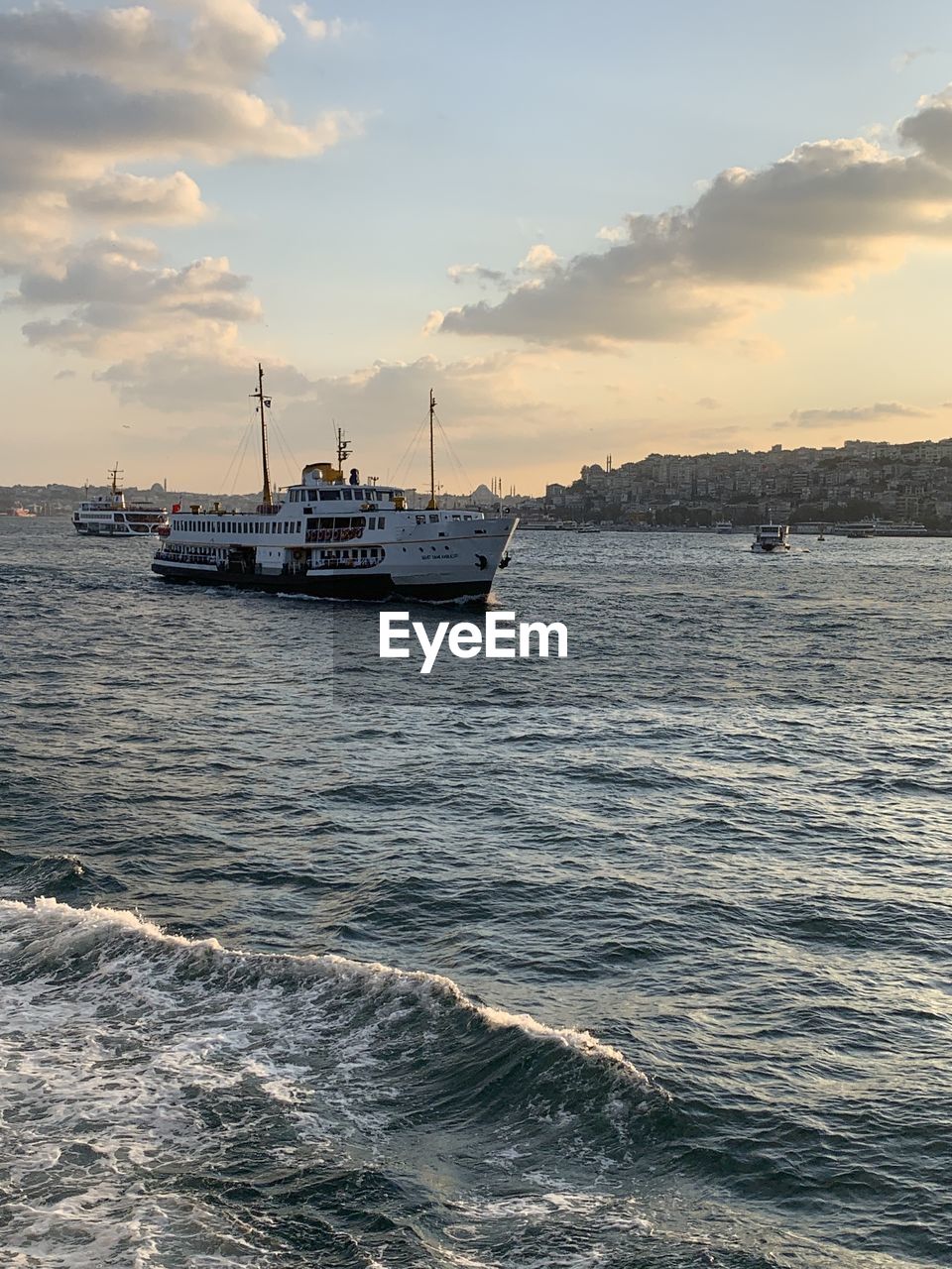 BOAT SAILING IN SEA AGAINST SKY DURING SUNSET