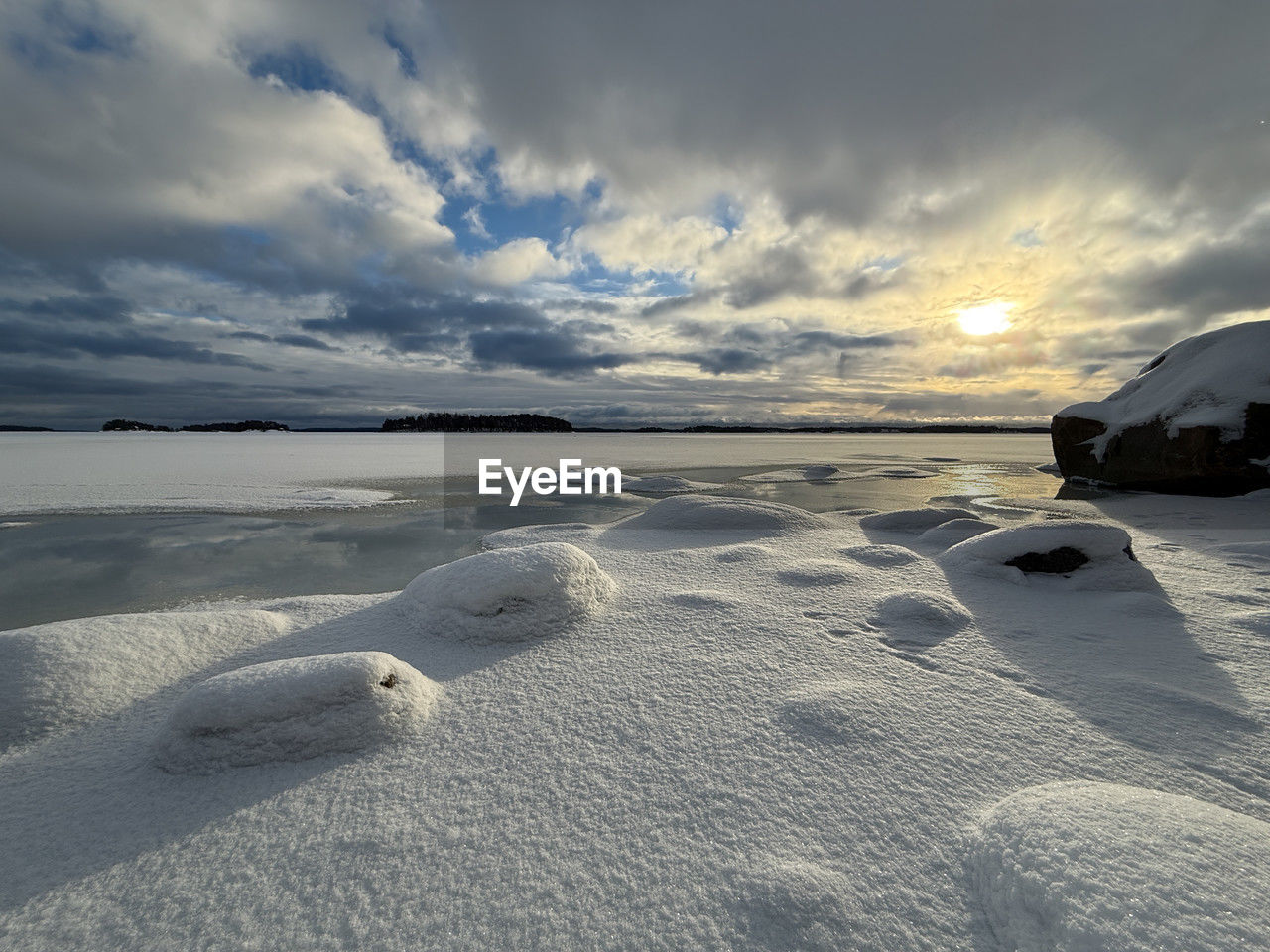 sky, snow, cloud, winter, land, scenics - nature, water, nature, sea, environment, beauty in nature, landscape, beach, ice, ocean, cold temperature, shore, sunset, tranquility, sand, no people, travel, coast, dramatic sky, wave, horizon, tranquil scene, travel destinations, sunlight, frozen, outdoors, reflection, vehicle, freezing, non-urban scene, day, tourism, lagoon