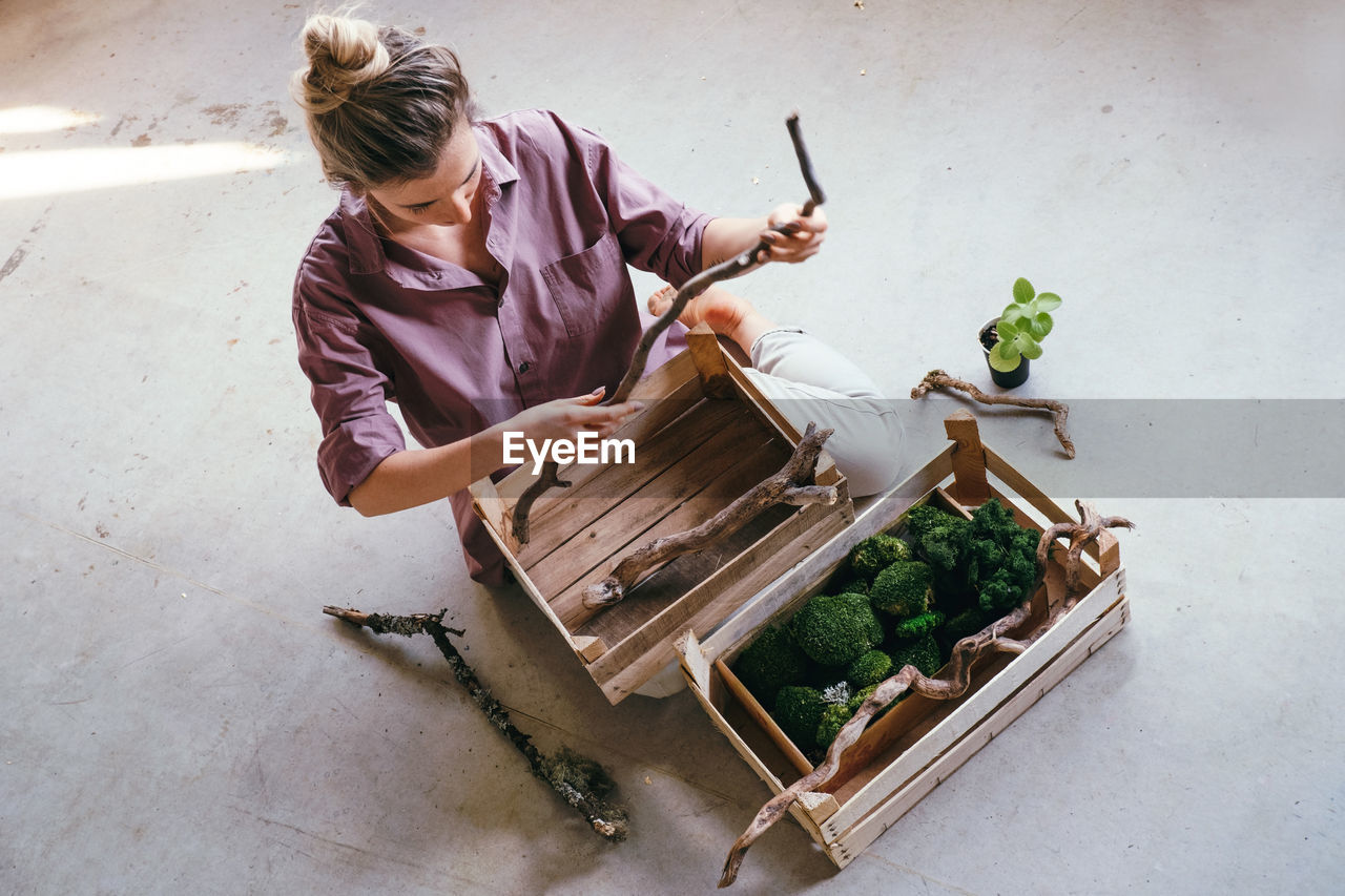 HIGH ANGLE VIEW OF WOMAN HOLDING VEGETABLES