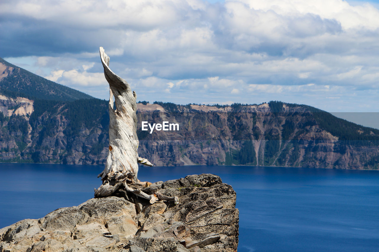 Rock formation by sea against sky