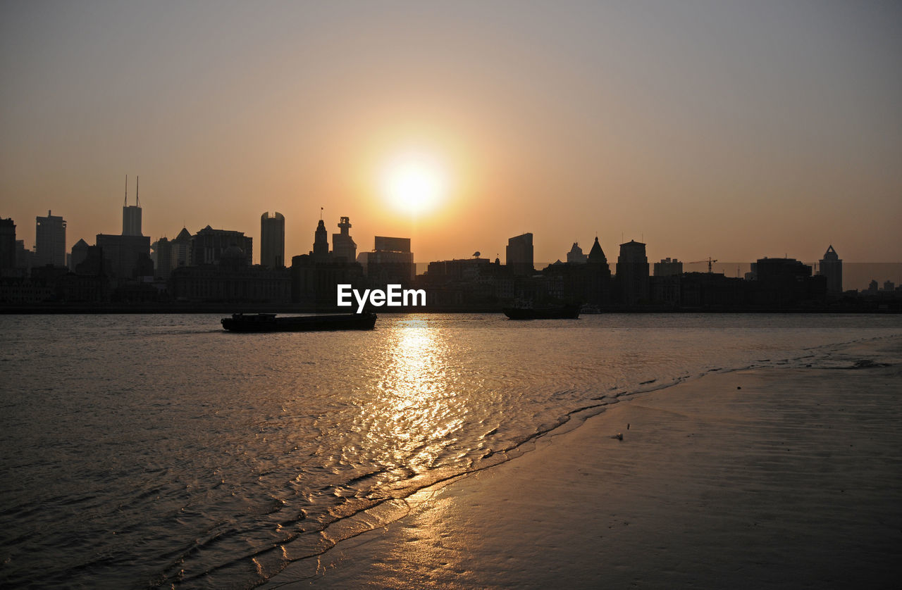 SILHOUETTE BUILDINGS IN CITY AT SUNSET