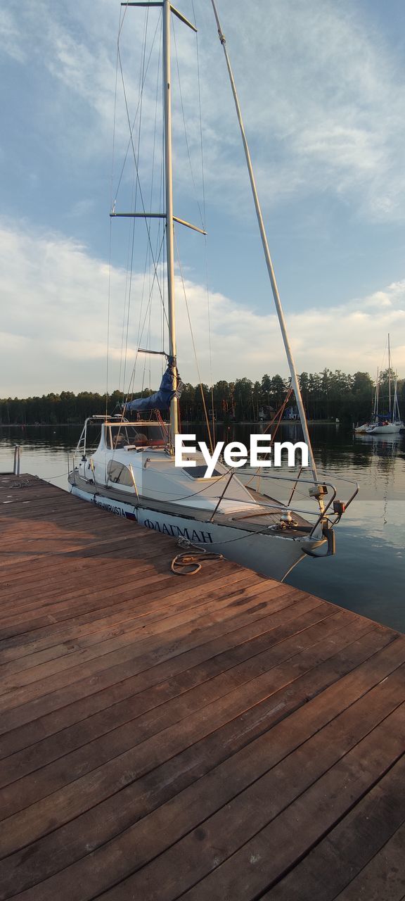 SAILBOATS MOORED AT HARBOR