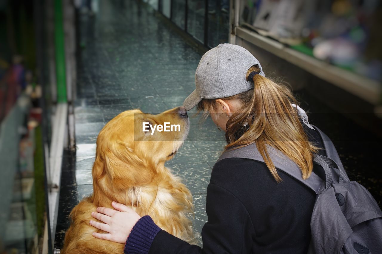 Woman with dog sitting in corridor