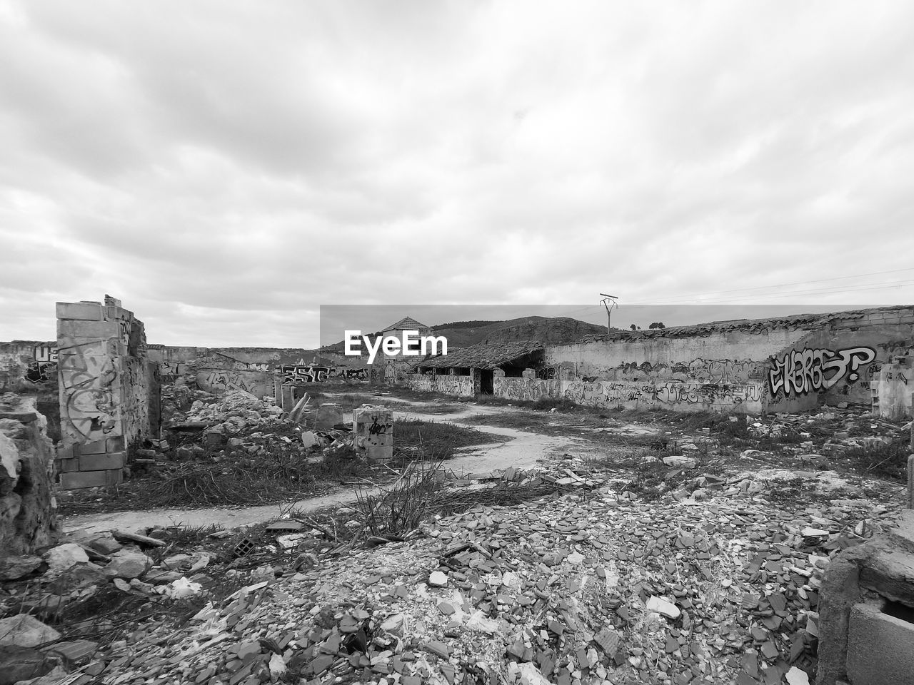 Black and white photography of abandoned industrial area with buildings in ruins and no people