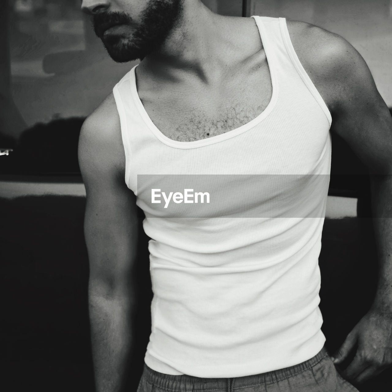 MIDSECTION OF MAN STANDING AGAINST CURTAIN