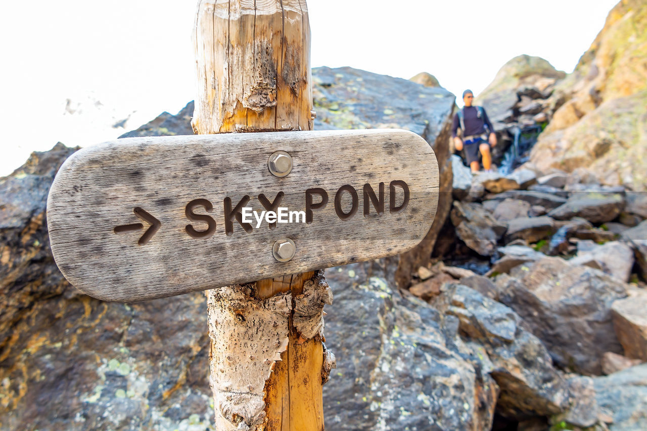 communication, text, sign, rock, nature, western script, day, outdoors, travel, wood, travel destinations, mountain, hiking, men, guidance, adult, activity, information sign, geology, land, warning sign