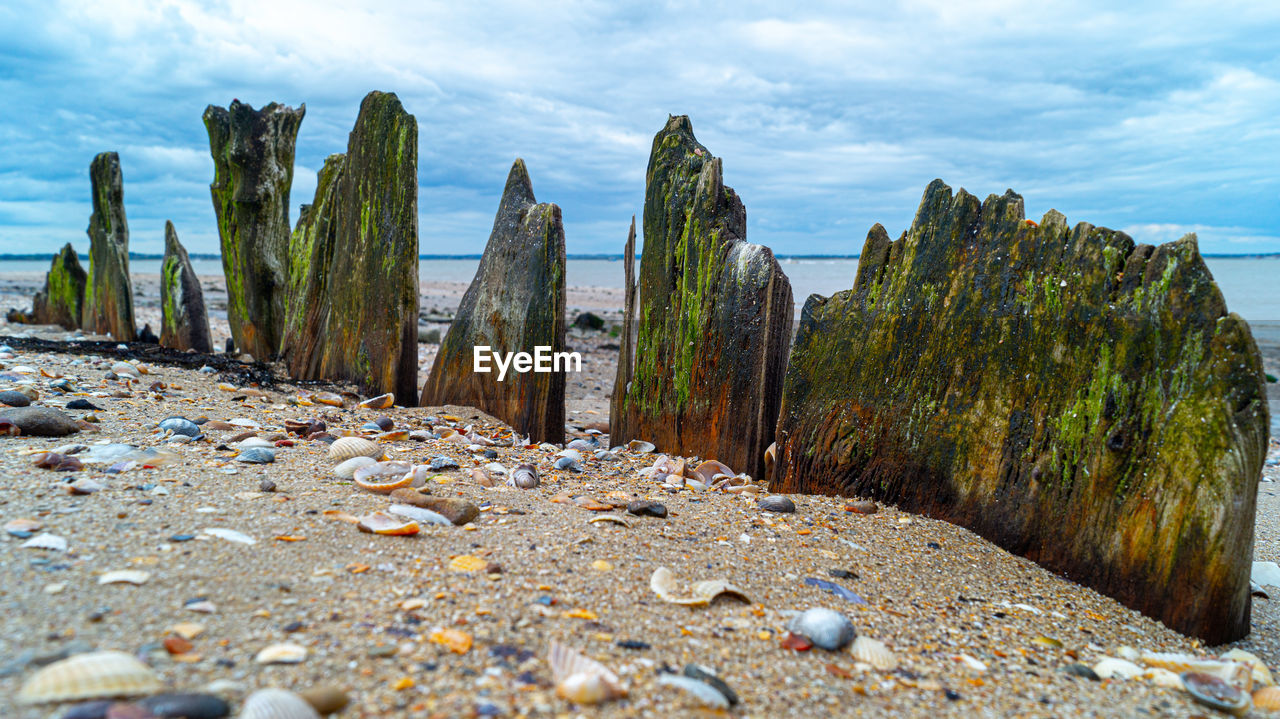 ROCKS ON BEACH AGAINST SKY