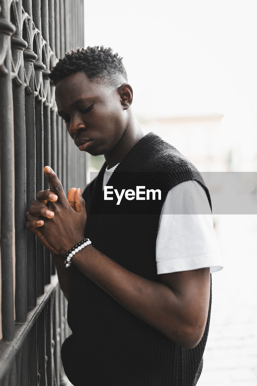 Young african man outdoor, street portrait. hands holding gun pose