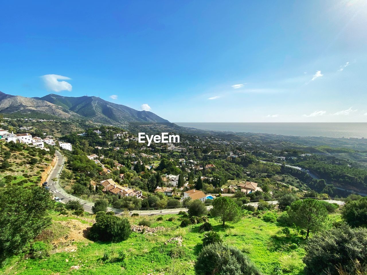 sky, mountain, landscape, environment, scenics - nature, nature, mountain range, plant, beauty in nature, architecture, tree, land, building exterior, building, city, built structure, cloud, travel destinations, sunlight, blue, tranquility, travel, no people, outdoors, day, green, tranquil scene, valley, aerial photography, tourism, cityscape, high angle view, plateau, residential district, sunny, idyllic, forest, town, clear sky, village