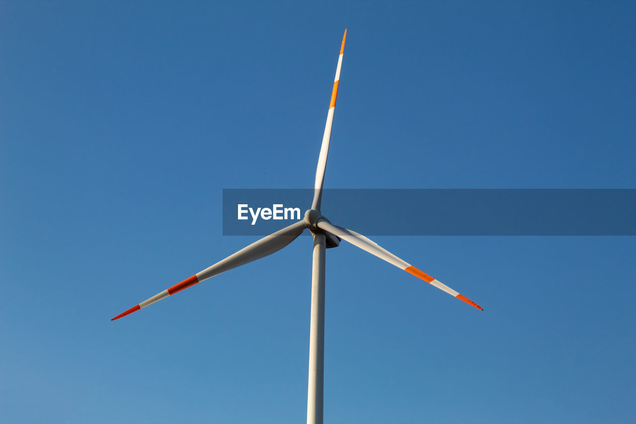 A wind turbine with a blue sky background