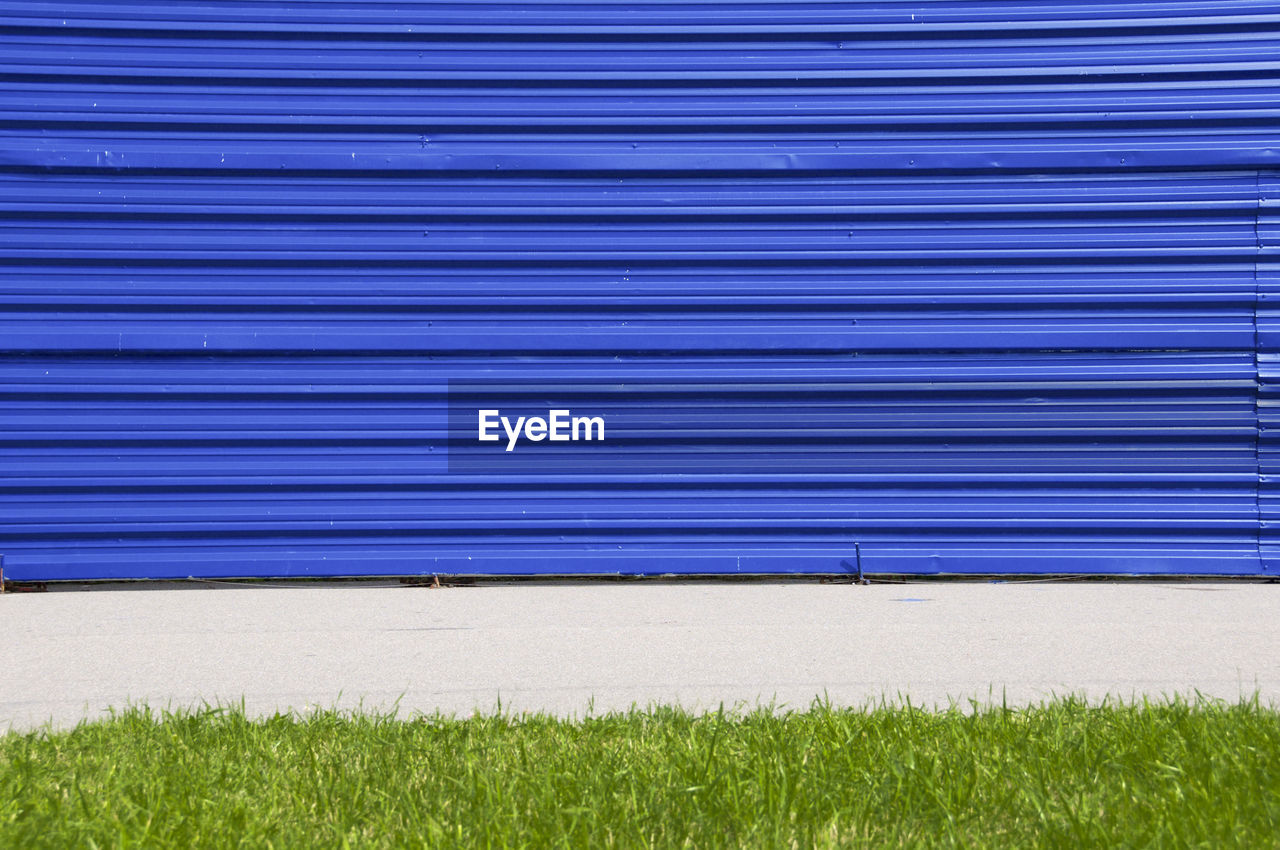 Closed blue shutter by field