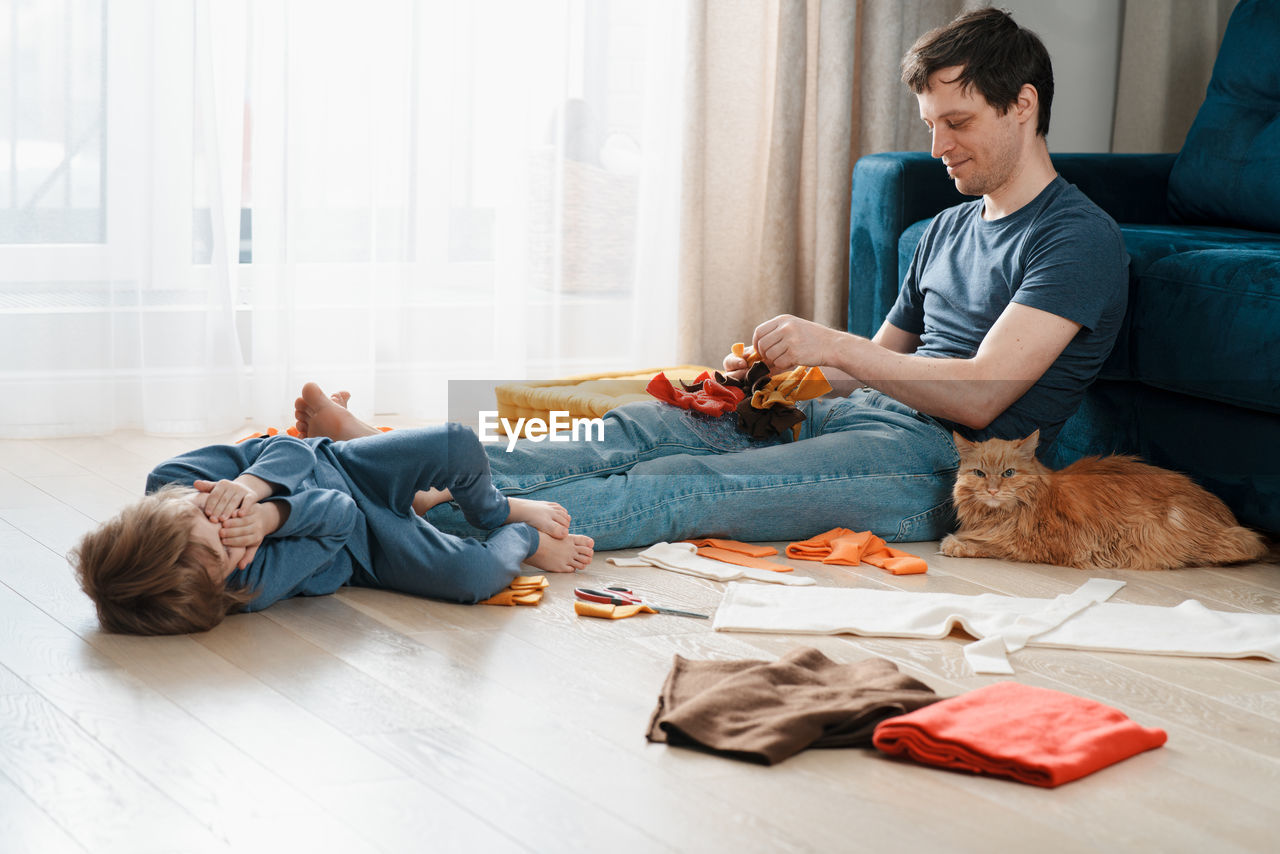 Family leisure activities. cute preschooler boy and his dad making diy snuffle mats for their pets