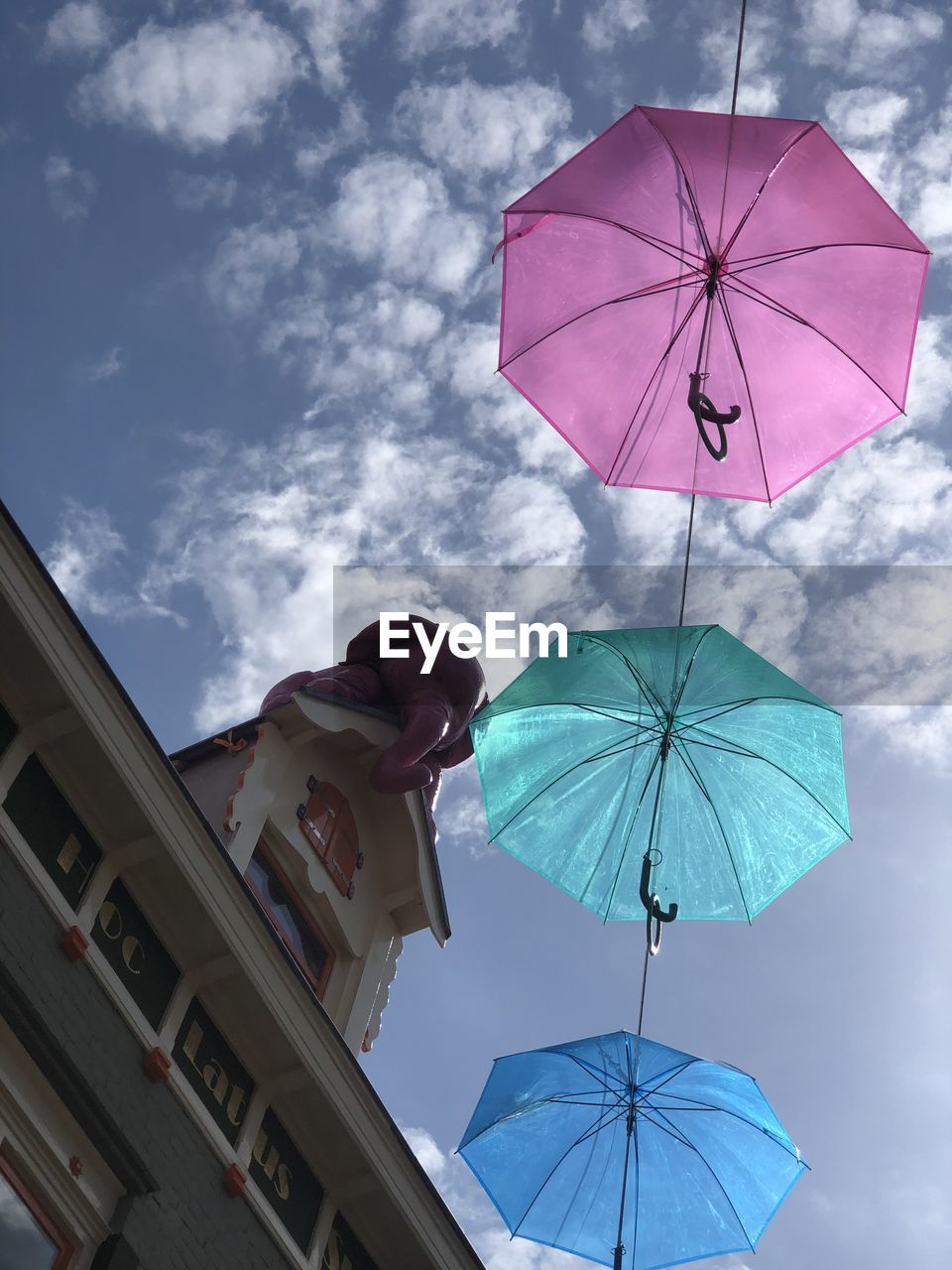 LOW ANGLE VIEW OF MULTI COLORED UMBRELLAS HANGING AGAINST SKY