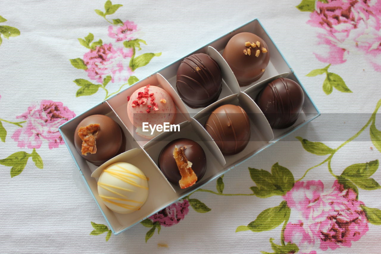 High angle view of chocolates in box on table