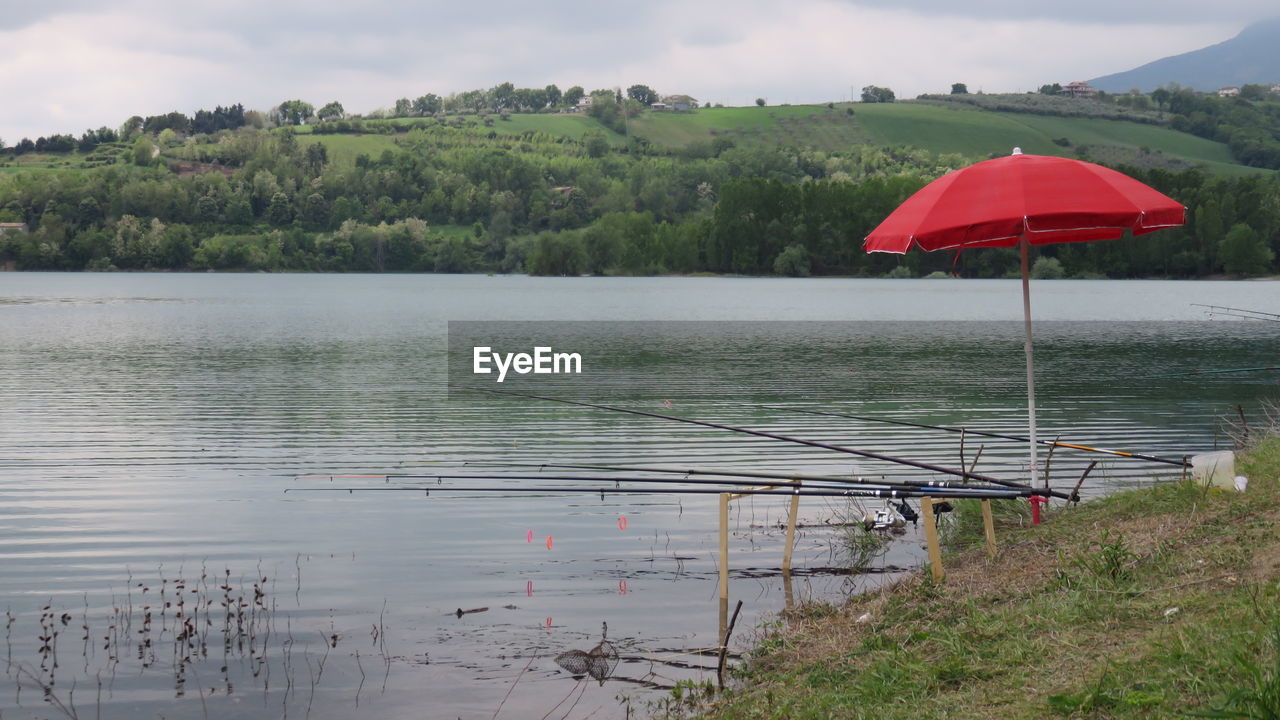 Calm lake against countryside landscape