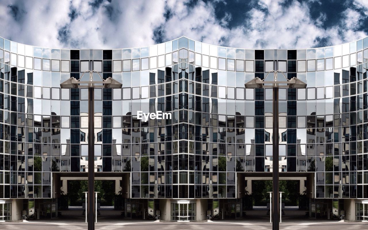LOW ANGLE VIEW OF MODERN BUILDINGS AGAINST CLOUDY SKY
