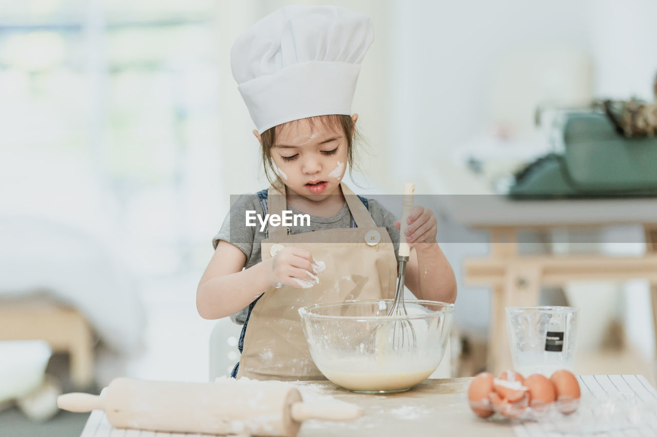 GIRL HOLDING ICE CREAM ON TABLE