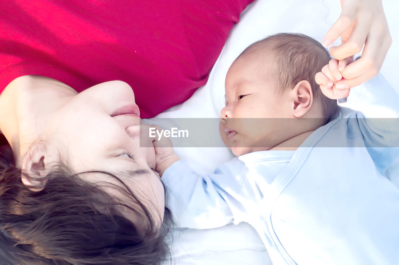 High angle view of cute baby boy sleeping on bed