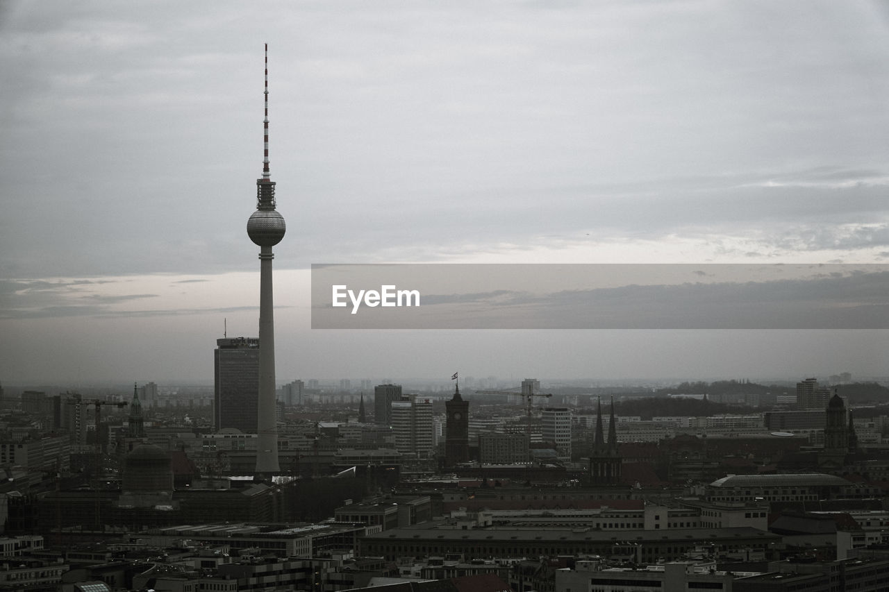 Communications tower in city at sunset