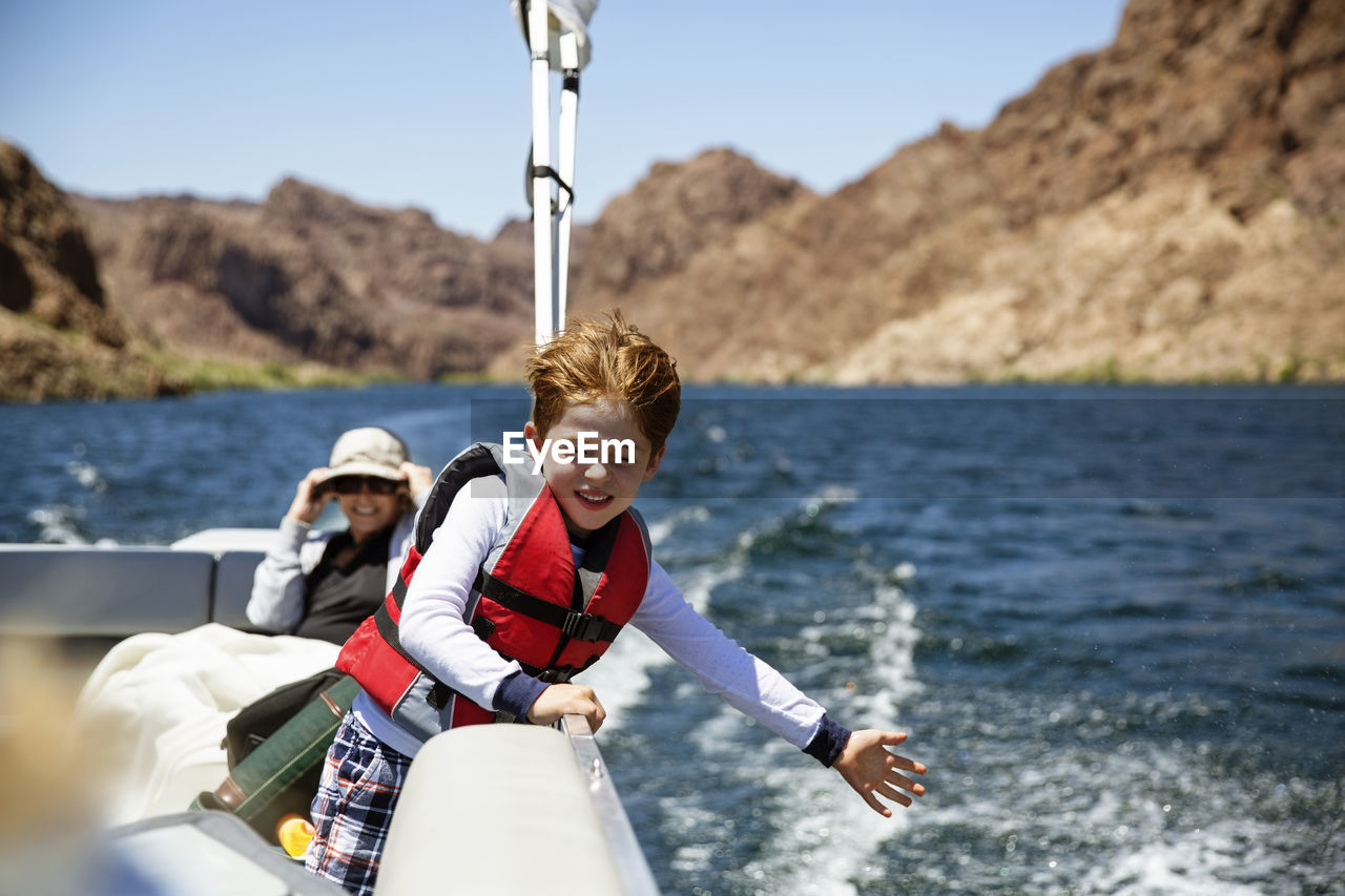 Happy boy traveling in boat with grandmother