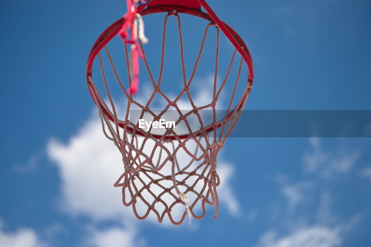 Low angle of basketball hoop against blue sky