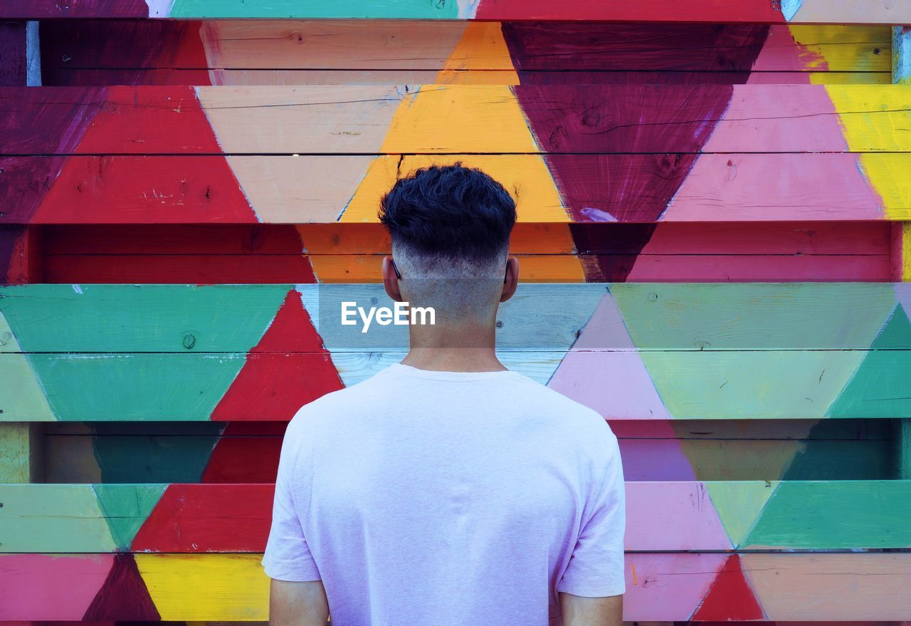 Man standing in front of multi colored wall