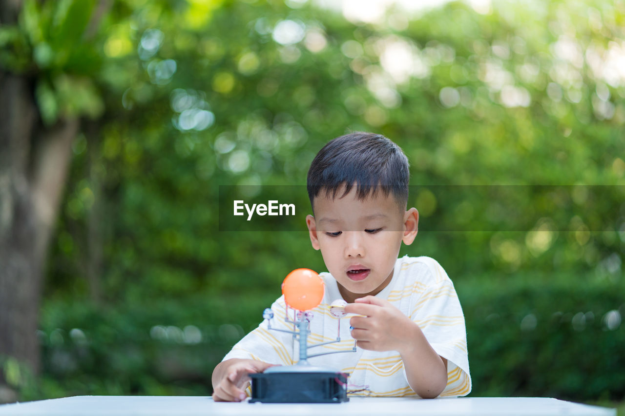 BOY LOOKING AWAY WHILE OUTDOORS