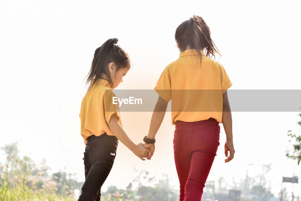 Two little girls holding hands.