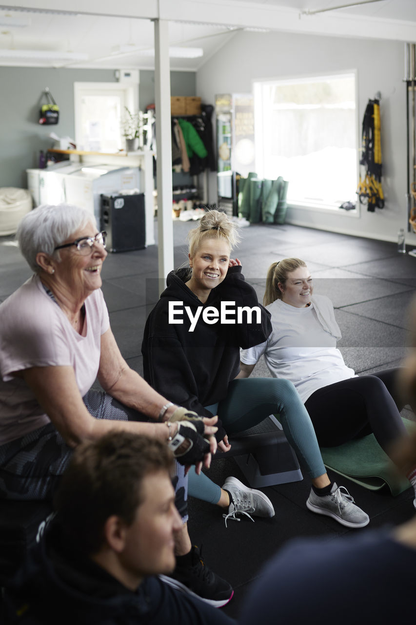 Smiling people talking together in gym