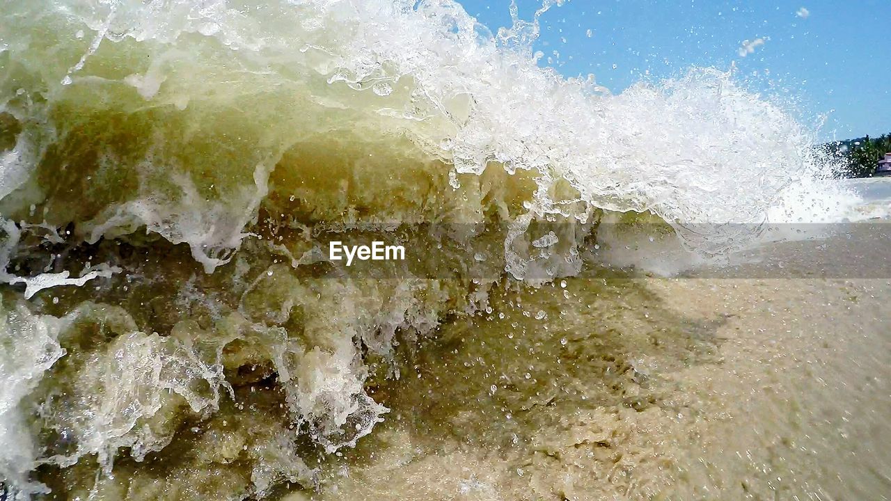 Sea waves flowing against clear blue sky