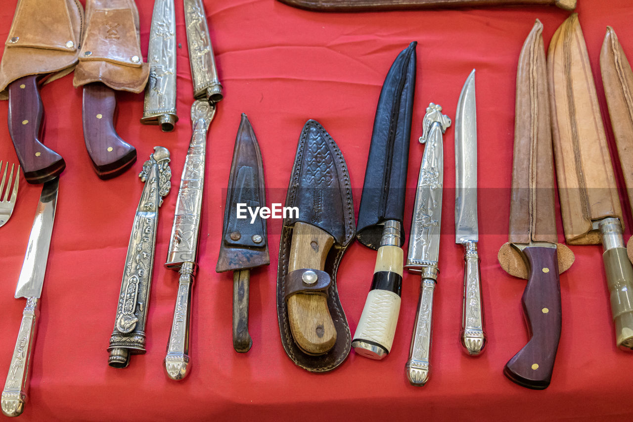 knife, weapon, work tool, red, melee weapon, hunting knife, variation, utility knife, cold weapon, tool, no people, hand tool, arrangement, in a row, large group of objects, firearm, order