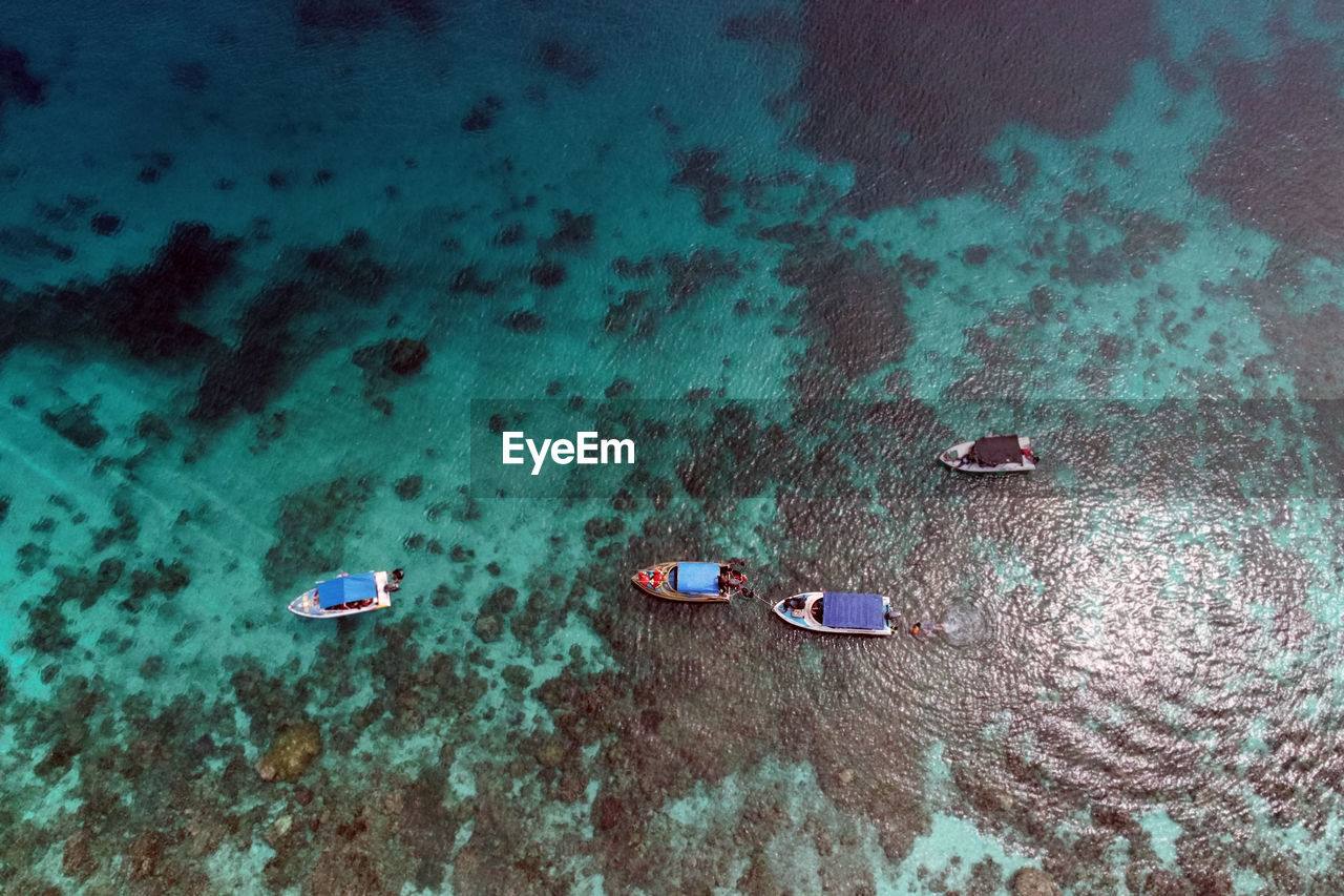 High angle view  of people and boat on beach using drone