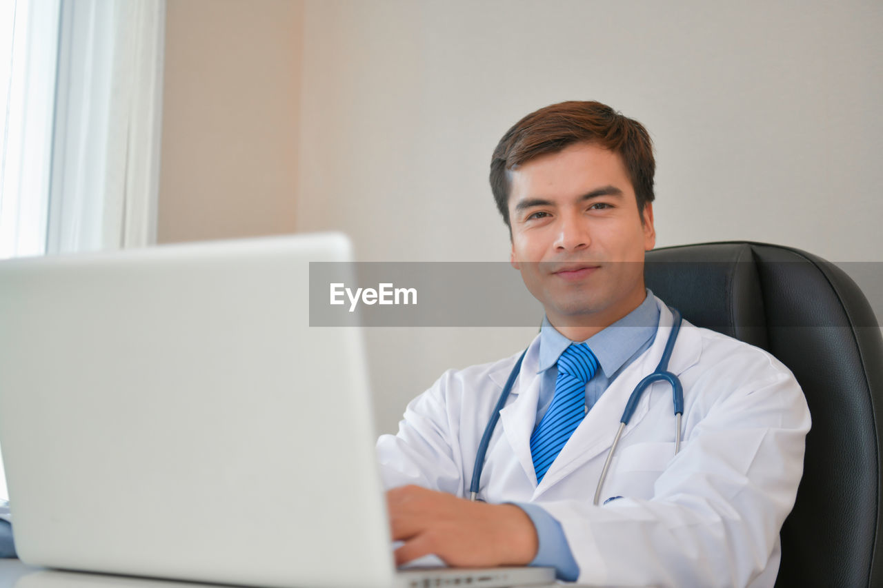 Doctor with laptop working in hospital