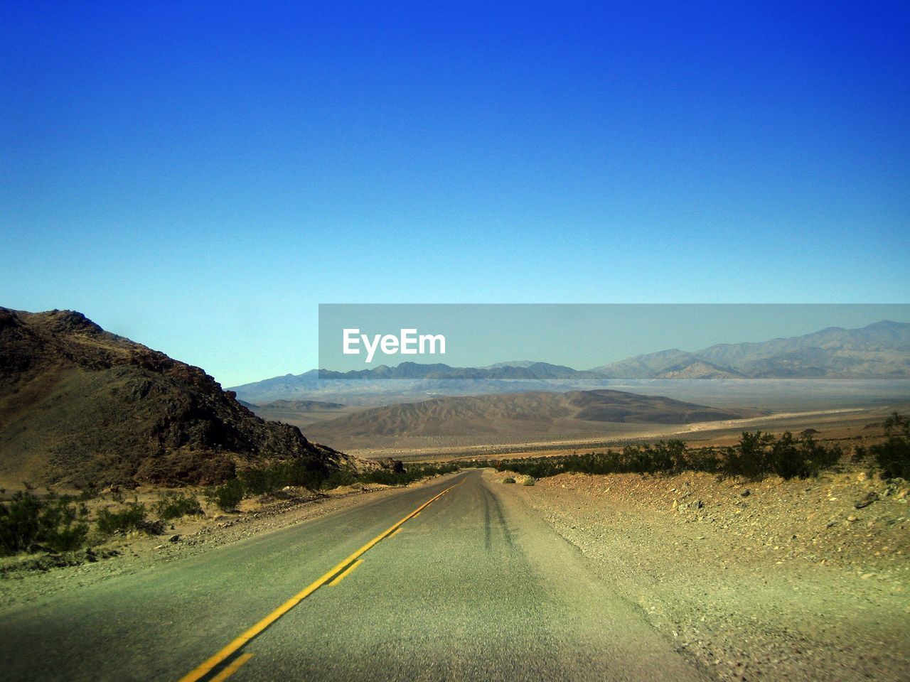 EMPTY ROAD ALONG COUNTRYSIDE LANDSCAPE