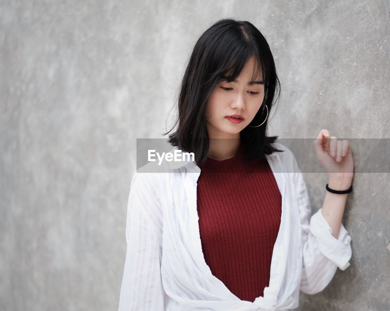 Portrait of woman standing against wall