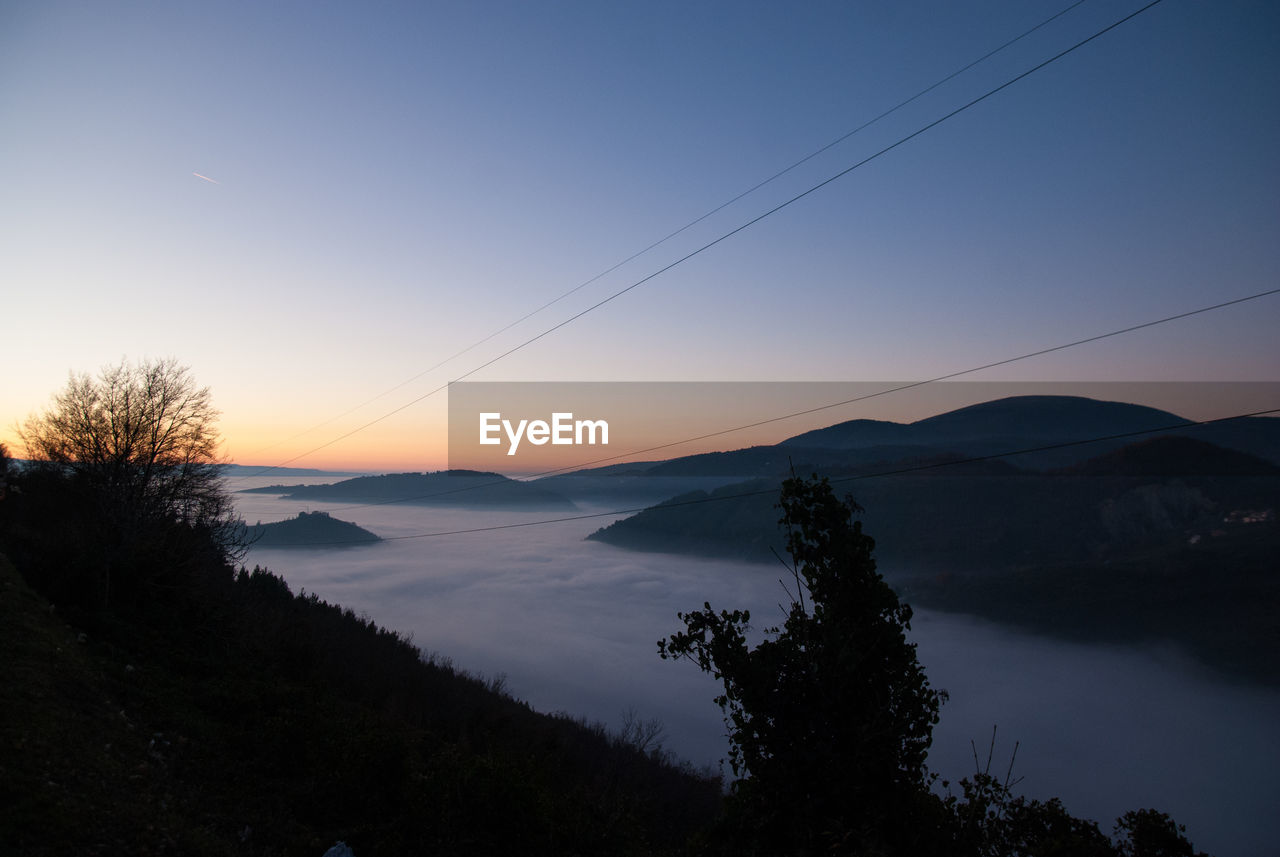 Scenic view of mountains against clear sky at sunset