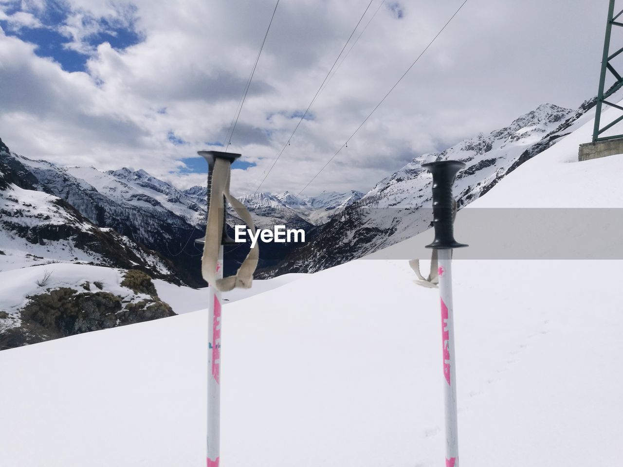 SNOW COVERED POLES AGAINST MOUNTAIN