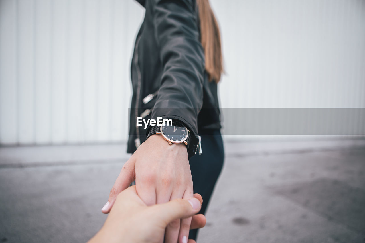 Close-up of couple holding hands in city