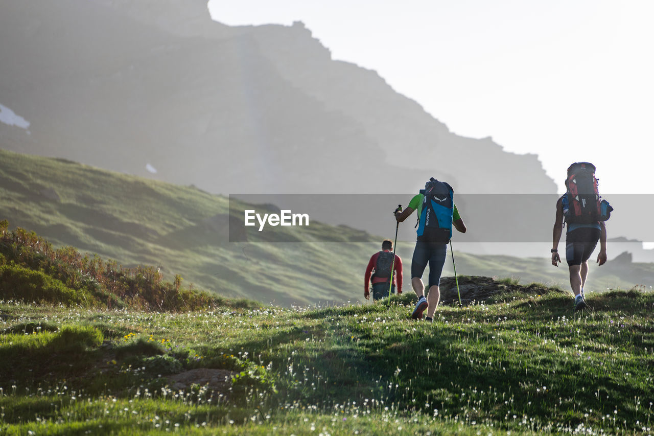 PEOPLE ON LANDSCAPE AGAINST MOUNTAINS